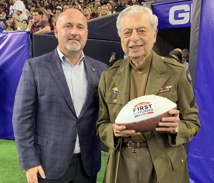 Two men posing with a football.